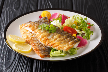 Golden grilled sea bass fillet with lemon and healthy vegetable 