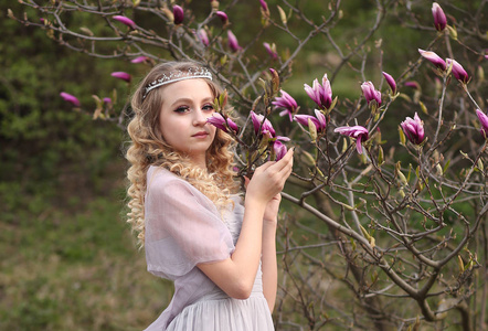 young beautiful girl in a light lilac dress in the garden where 