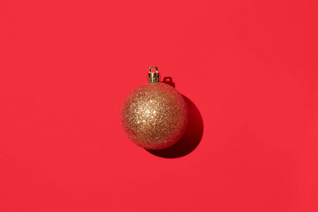 闪亮的金色圣诞球，红色背景。