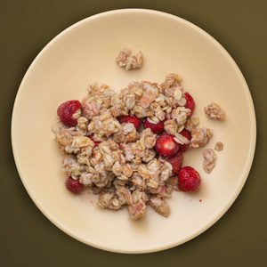  muesli on a beige plate on a green brown background. granola wi