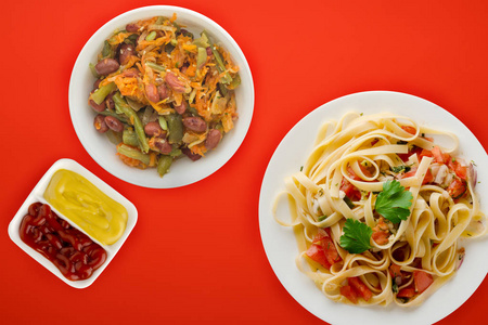 spaghetti on a white plate. spaghetti tomatoes, onions, cabbage 