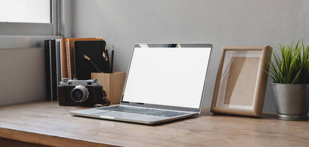 Cropped shot of comfortable workspace with blank screen laptop c