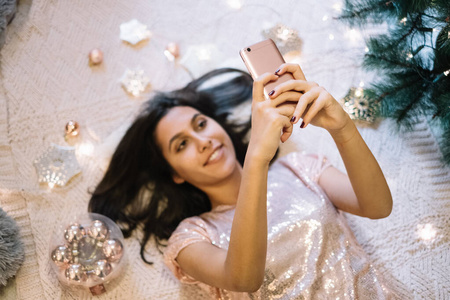 躺在地毯上拿着智能手机的女人照片