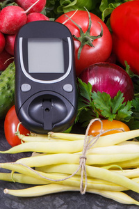 血糖仪和新鲜蔬菜作为食物的维生素来源。健康的生活方式和营养