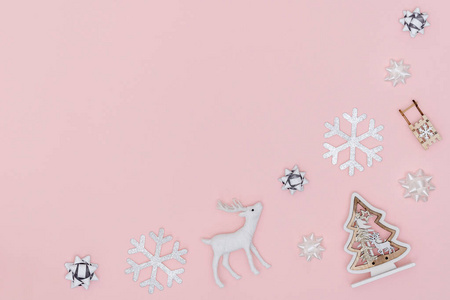 新年和圣诞作文。从雪花，圣诞树，礼物蝴蝶结，鹿在粉彩纸背景的框架。俯视图，平面布置，复制空间