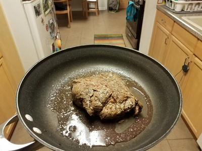 厨房里的煎锅里拿着牛肉汁图片