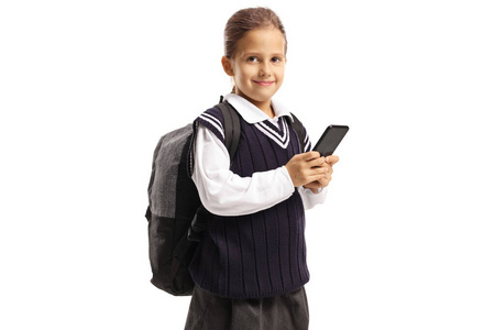 Schoolgirl in a uniform with a backpack holding a smartphone 