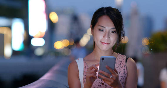 女性晚上使用智能手机