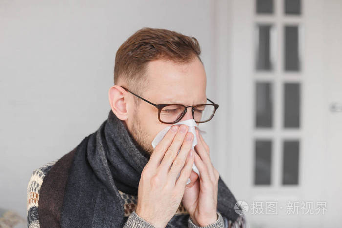 年轻的白人男子感冒了擤鼻涕