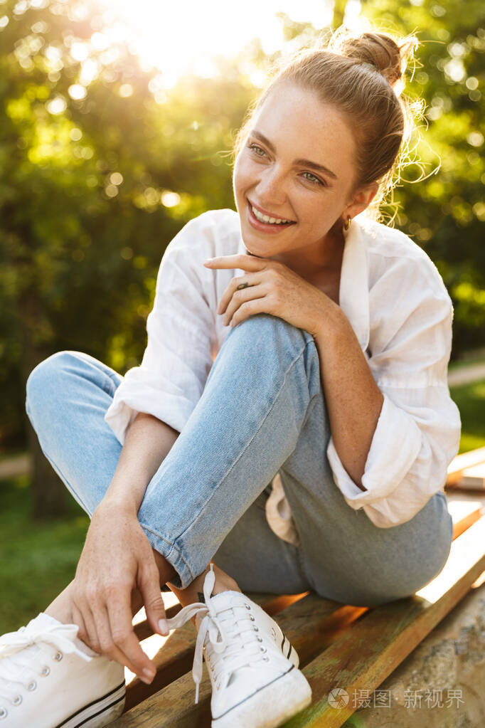 可爱的年轻女孩穿着随意坐在长椅上