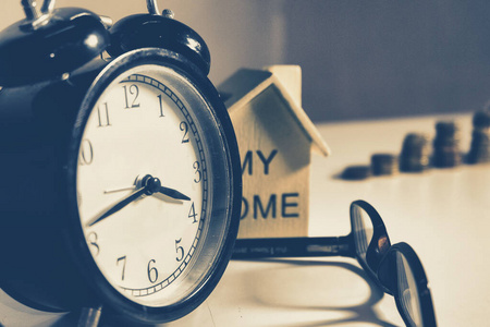 Time management concept, alarm clock on working table with eyegl