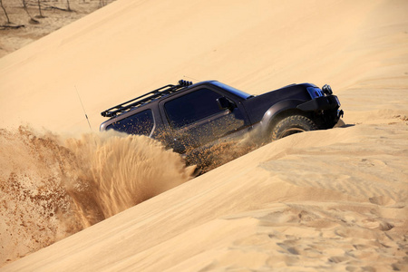 一辆越野车在沙漠中行驶.照片