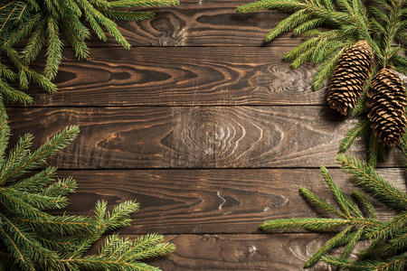 fir branches and cone on dark old wooden background 