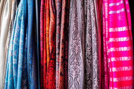 不同颜色的丝绸纺织不同颜色的布匹在垂直悬挂中聚集照片