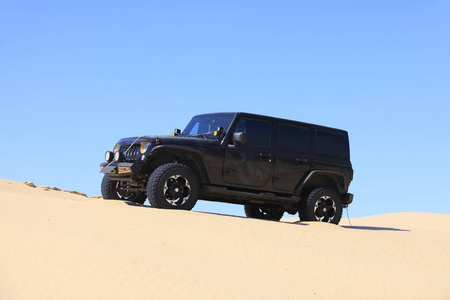 一辆越野车在沙漠中行驶.照片