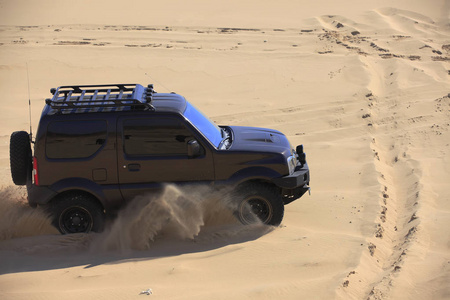 一辆越野车在沙漠中行驶.照片