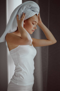 淋浴后，头上戴着毛巾的女人正在放松