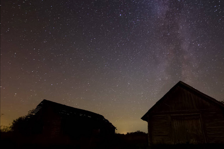 村里木屋上空星光灿烂。星空背景图片星星在夜空和银河系。