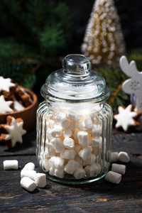 垂直放置甜棉花糖和圣诞装饰品的罐子