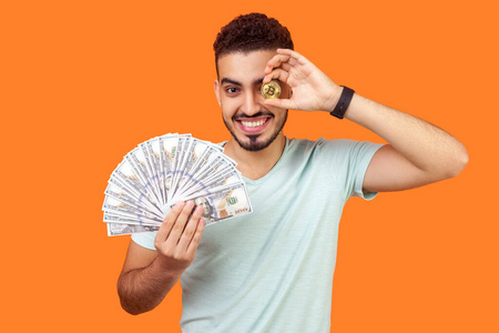 快乐的有钱的黑发男人拿着美元和衣服的肖像照片