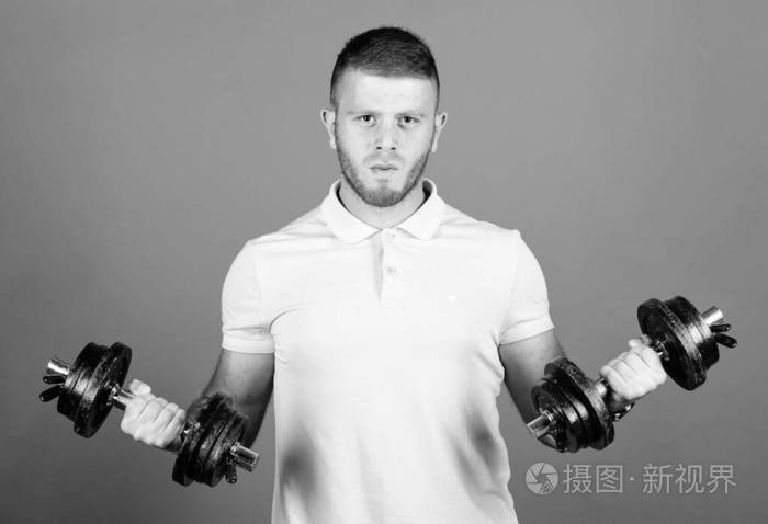身体肌肉发达的男子用哑铃锻炼运动员强壮的二头肌和三头肌运动员使用