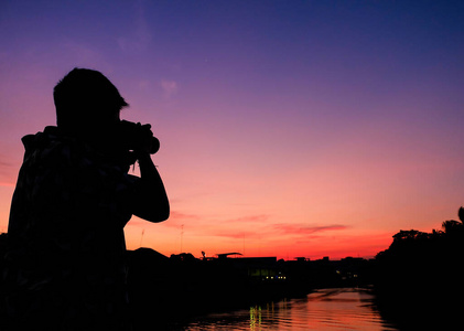 摄影师在黄昏拍摄照片。泰国。