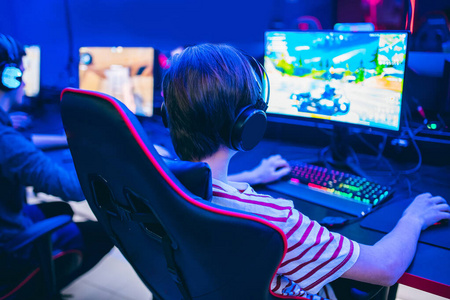 职业玩家玩锦标赛在线电子游戏带耳机的电脑，红色和蓝色
