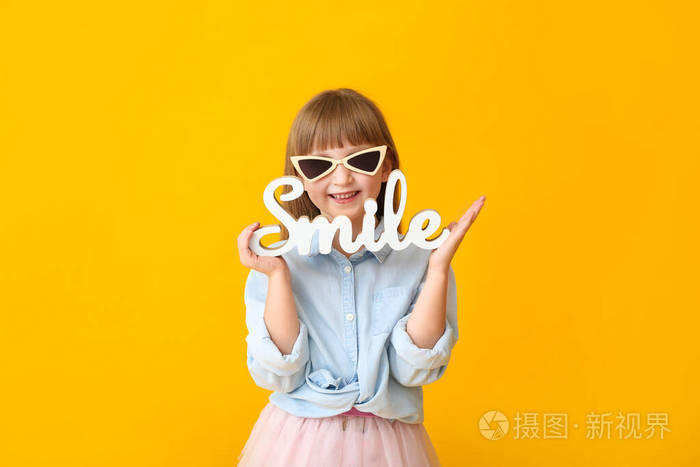 可爱的小女孩在彩色背景上装饰成单词smile