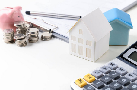 Paper house model with coin and piggy bank 