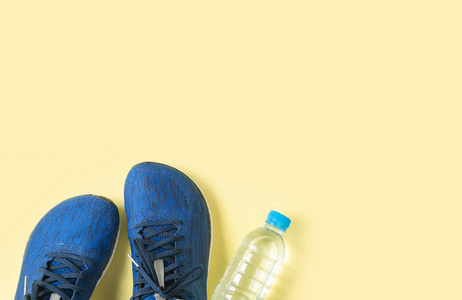 蓝色的跑鞋和黄色背景的水瓶，
