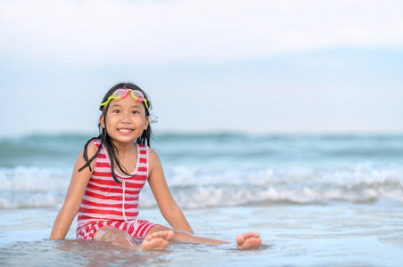 Happy cute asian girl playing wave on beach, 