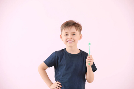 彩色背景上的小男孩拿着牙刷的肖像