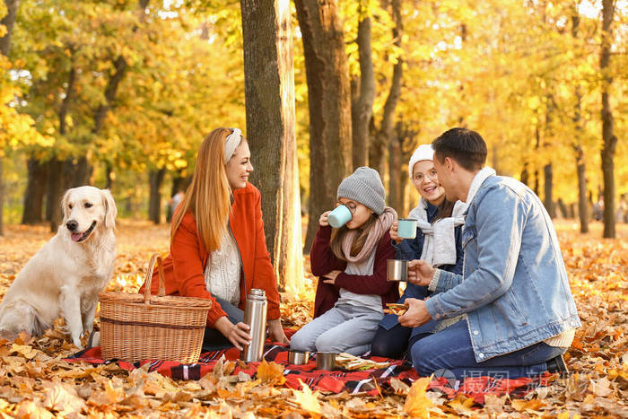 快乐的一家人在秋天公园野餐