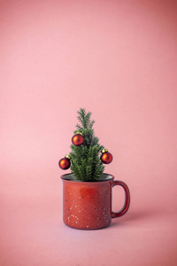 粉红色背景的杯子里有装饰的圣诞树。C