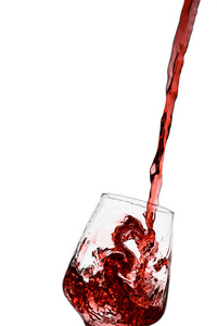 在白色背景下向玻璃杯中倒入红酒