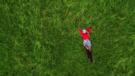 女孩躺在绿色草坪上俯视着无人机照片