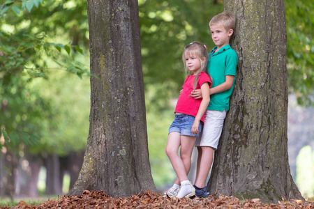 Portrait of two pretty cute children boy and girl standing near 