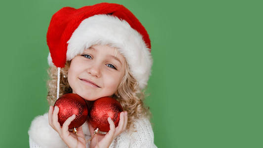 圣诞快乐小女孩戴圣诞帽，明亮的绿色背景。