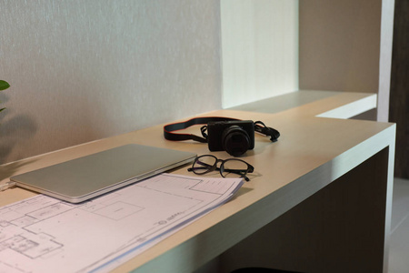建筑师图纸草图和笔记本电脑放在办公桌上的办公桌上