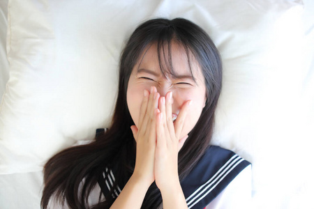 Portrait japanese school girl sleep and smile in white tone bed 