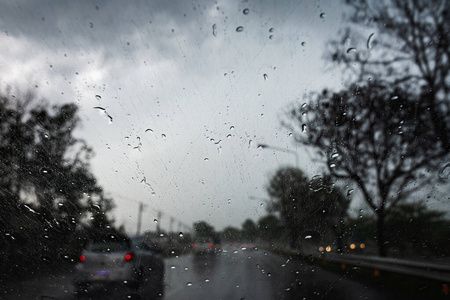 在大雨和风暴潮中，雨滴落在汽车玻璃上。