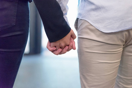 Young couple joining hands in cafe place. Man and woman holding 