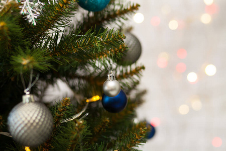 美丽的绿色圣诞树，装饰着球和花环。特写照片。闪闪发光的背景