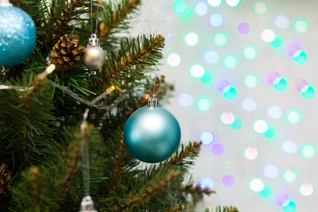 美丽的绿色圣诞树，装饰着球和花环。特写照片。闪闪发光的背景