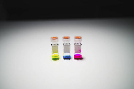 三种颜色的液体在不同的LCMS玻璃瓶中，在白色b上