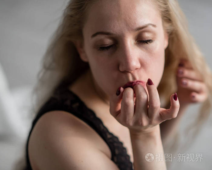 穿着黑色内衣的金发美女舔着手指女人幻想吹箫