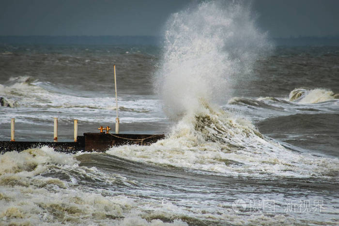 防波堤和港口在暴风雨天气与巨大的海浪冲击墙码头.