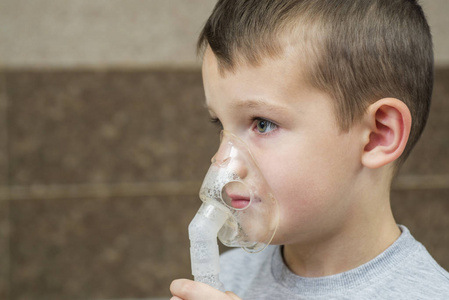 孩子拿着面罩吸入器。感冒或流感后胸部感染导致呼吸困难和长期咳嗽的儿童