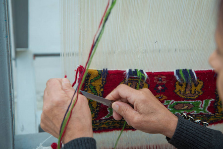手工地毯的编织和制造。女人的手织地毯。女人用手编织地毯。