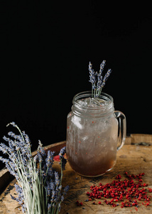 An alcoholic beverage garnished with lavender and peppercorns 